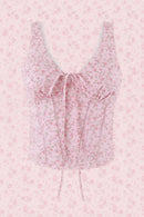 A pink floral sleeveless crop top with a lace-trimmed V-neckline, front tie detail, and vertical lace-up front, shown on a plain white background, Obroi