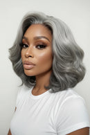 A gray wavy wig shown on a model from multiple angles, including a large front view, three smaller side and back views, against a plain light background, Obroi