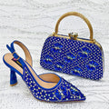 Blue embellished shoe and matching handbag on a textured white background, Obroi