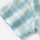 A close-up of a plaid fabric, likely a shirt sleeve, featuring a pattern of light blue, mint green, and white intersecting stripes on a white background, Obroi