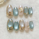 Set of nail designs with gold leaf and pearl accents on a light background, Obroi
