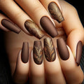 Close-up of hands with brown nail polish and gold feather designs, Obroi