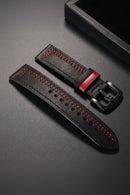 Black leather watch strap with red stitching on a dark surface ,Obroi