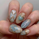 Nails with decorative designs featuring hearts and flowers on a light background, Obroi