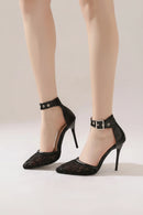 Black high-heeled shoes with lace detailing and buckles on a neutral background, Obroi
