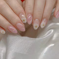 Close-up of hands with pink nail polish and floral designs on a white fabric background, Obroi
