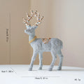 Decorative reindeer figure with glittery finish and decorative crown on a beige , Obroi