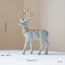 Decorative reindeer figure with glittery finish and decorative crown on a beige , Obroi