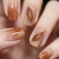 Nails with brown nail polish and gold feather designs on a blurred background, Obroi