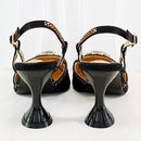 A pair of black high-heeled slingback sandals with embellished straps and a glossy sculptural heel, shown from the back on a white background, Obroi
