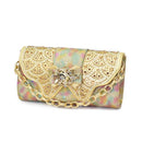 Gold clutch bag with floral pattern and chain strap on a white background, Obroi