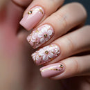 Nails with floral design and pink polish on a blurred background, Obroi