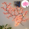 Decorative LED branch with pink flowers on a wall, inset showing a close-up of a pink flower, Obroi