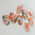 Nail art with floral and fish design on a white background, Obroi
