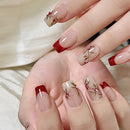 Close-up of hands with red and clear nail polish design on a neutral background, Obroi