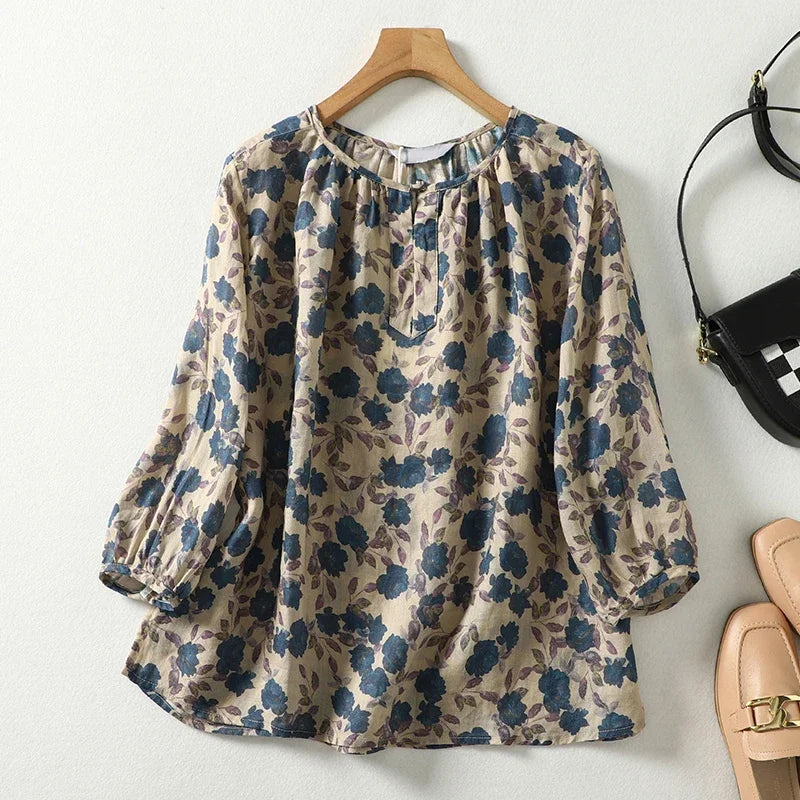 Floral patterned blouse on a hanger with shoes and a handbag in the background.