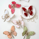 Decorative butterflies in various colors on a white surface with pearls, Obroi