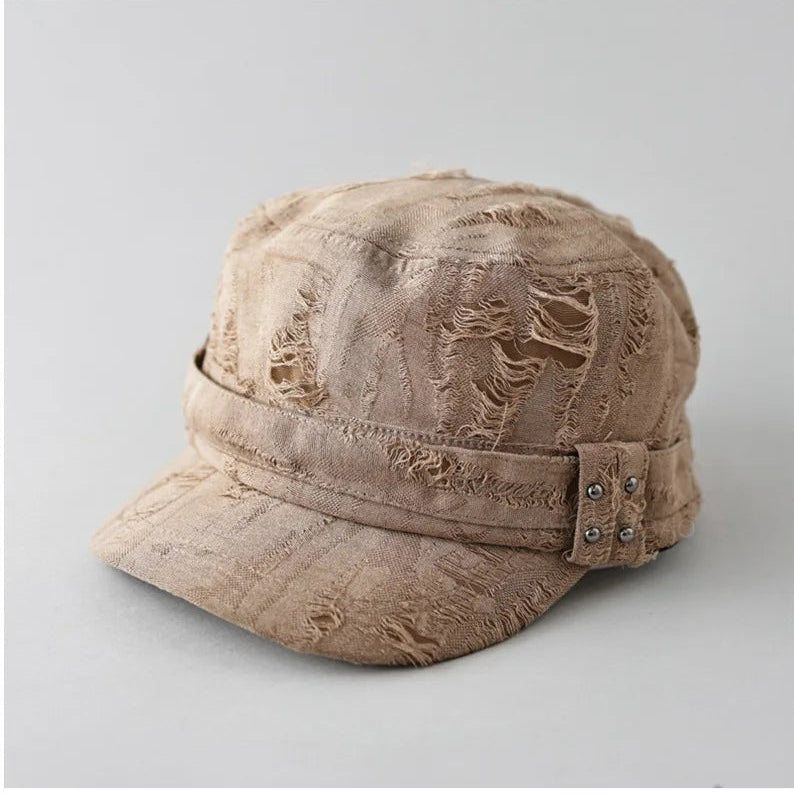 Beige distressed cap with embellishments on a light gray background, Obroi