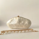 Silver clutch bag with a gold chain on a light beige background, Obroi