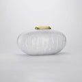 White textured vase with a gold lid on a light gray background, Obroi