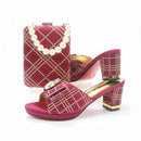 Red high-heeled shoes with gold accents and a matching clutch on a white background, Obroi