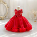 A bright red toddler girl's party dress displayed on a mannequin. The sleeveless dress features a floral embroidered bodice, a matching red satin waistband with a large bow, and a voluminous tiered tulle skirt with ruffled trim, Obroi