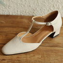 White shoe with a strap on a wooden surface, Obroi