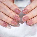Close-up of hands with pink glittery nail polish on a white background, Obroi