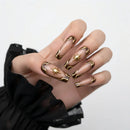 Hand with gold-accented nails on a white background, Obroi