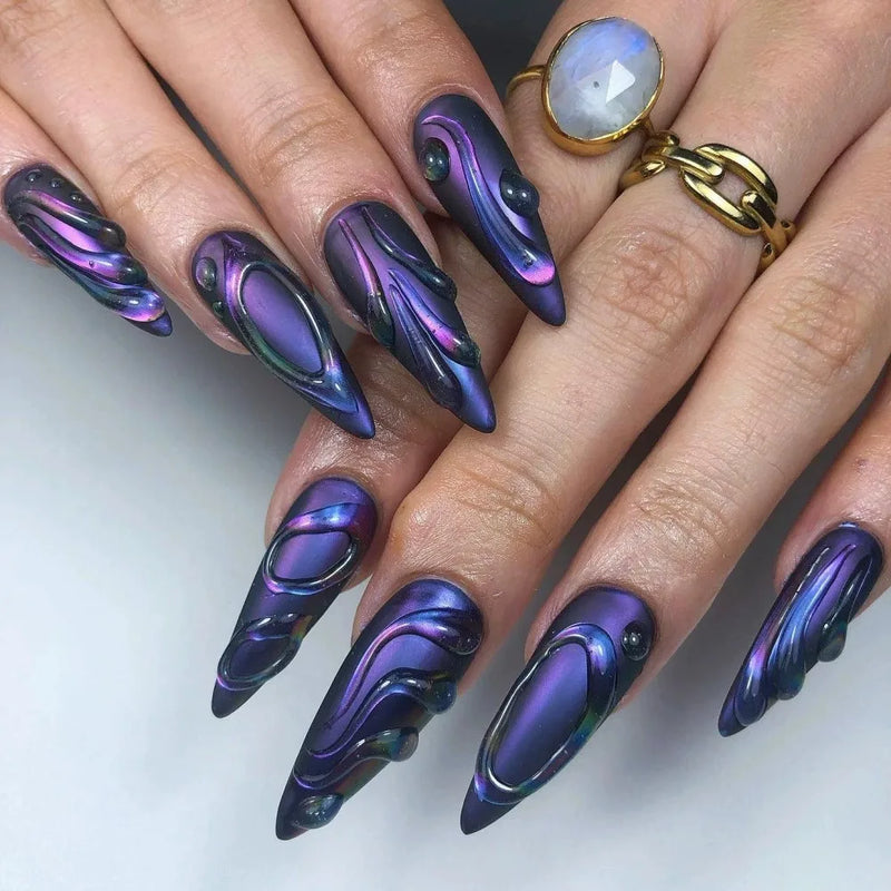 Nails with a metallic purple and blue design on a white background