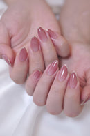 Close-up of hands with glossy almond-shaped nails in a soft pink shade with tiny silver French tips, Obroi