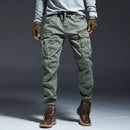 Person wearing green cargo pants and brown boots on a gray background, Obroi