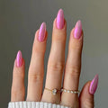 Hand with pink nail polish on a plain background, Obroi