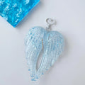 Obroi Light blue angel wings with a heart-shaped clasp on a white background