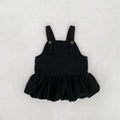 Black overall dress with a ruffled skirt on a light gray background, Obroi