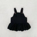 Black overall dress with a ruffled skirt on a light gray background, Obroi