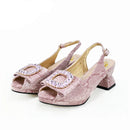 Pink high-heeled shoes with embellishments on a white background, featuring the brand ' Obroi'.