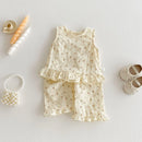 Children's floral outfit with ruffled top and shorts on a light gray background