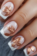 Nails with white polish and copper leaf designs on a textured surface, Obroi