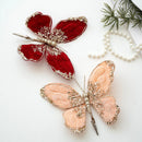 Two butterfly-shaped hair accessories with red and peach colors on a white background, Obroi
