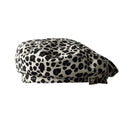 A structured flat cap with a black and off-white leopard print pattern, shown against a plain white background, Obroi