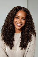Woman with long, curly hair smiling against a plain background, Obroi
