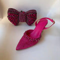 Pink high-heeled shoes with embellishments and a matching pink bow clutch on a light , Obroi