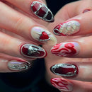 Close-up of hands with red and silver nail art on a dark background, Obroi