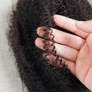 Close-up of a hand holding a section of curly hair, with a blurred background, Obroi