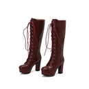 Pair of brown knee-high boots with red laces on a white background