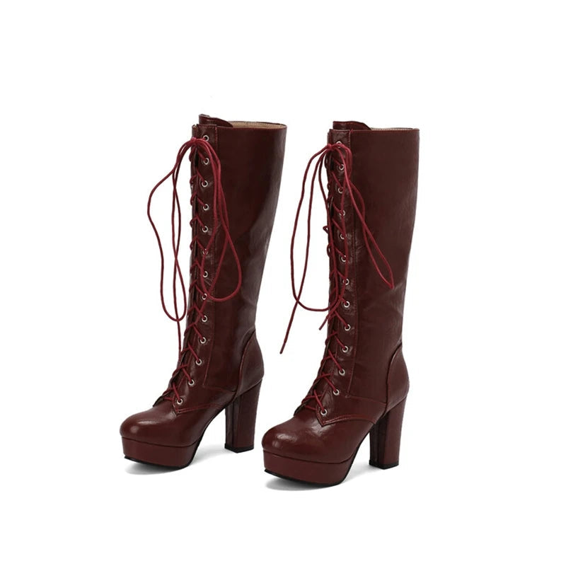 Pair of brown knee-high boots with red laces on a white background