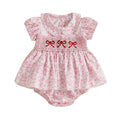 A baby girl's short-sleeve romper in a light pink floral print, featuring a smocked yoke with three red embroidered bow details and a ruffled flutter hem, Obroi