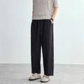 Person wearing black wide-leg pants and a striped shirt on a plain background, Obroi