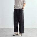Person wearing black wide-leg pants and a striped shirt on a plain background, Obroi